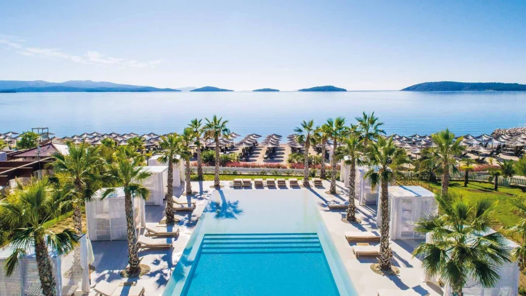 an aerial view of a swimming pool surrounded by palm trees